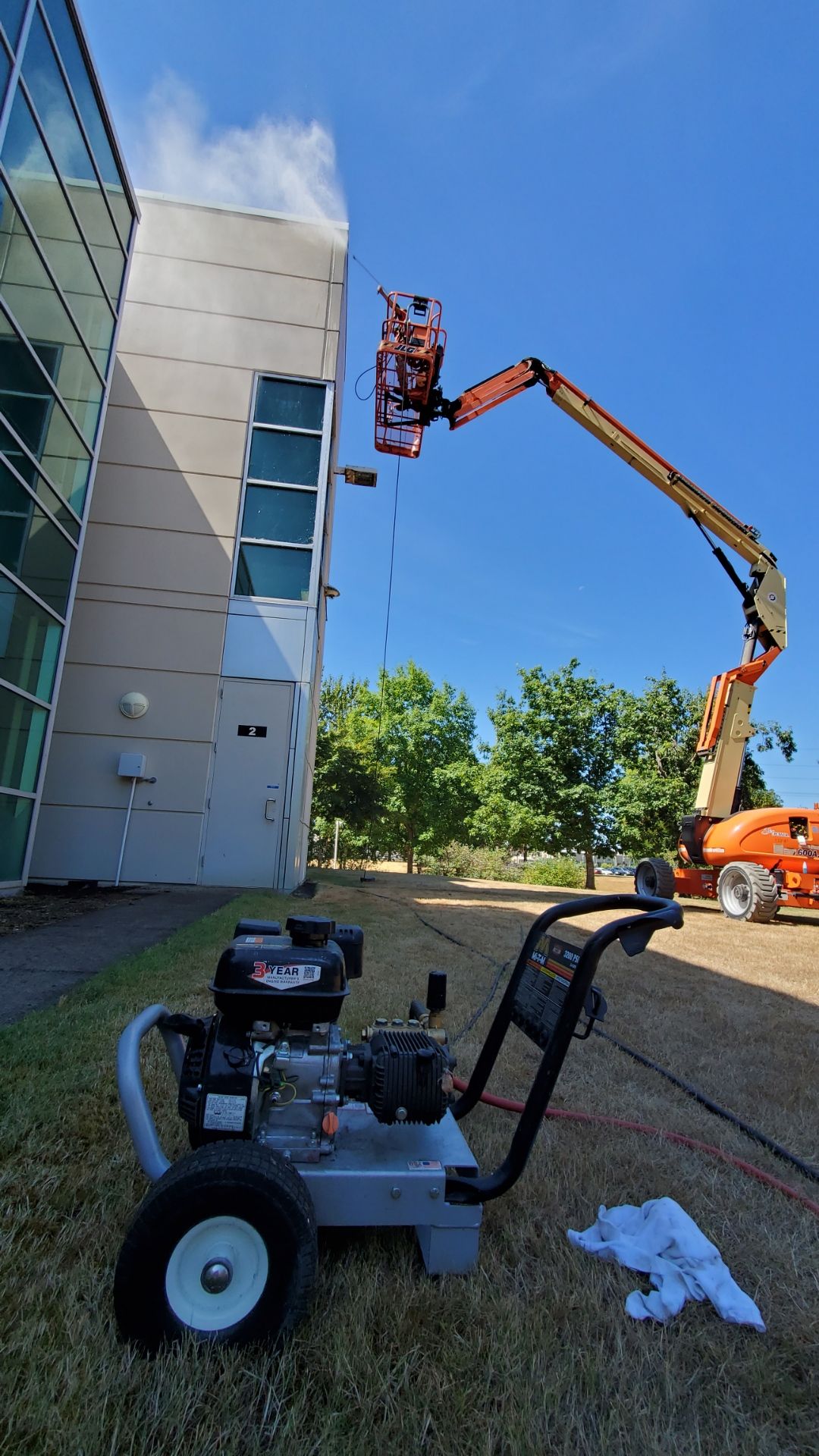 A pressure washer is sitting on the grass in front of a building.