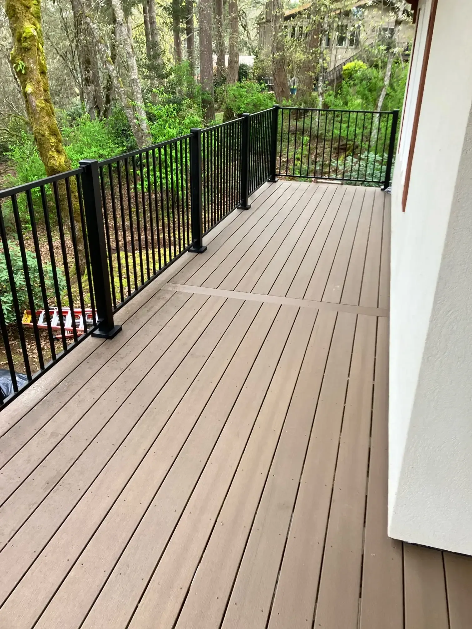 Close-up of brown composite boards and black metal rail.