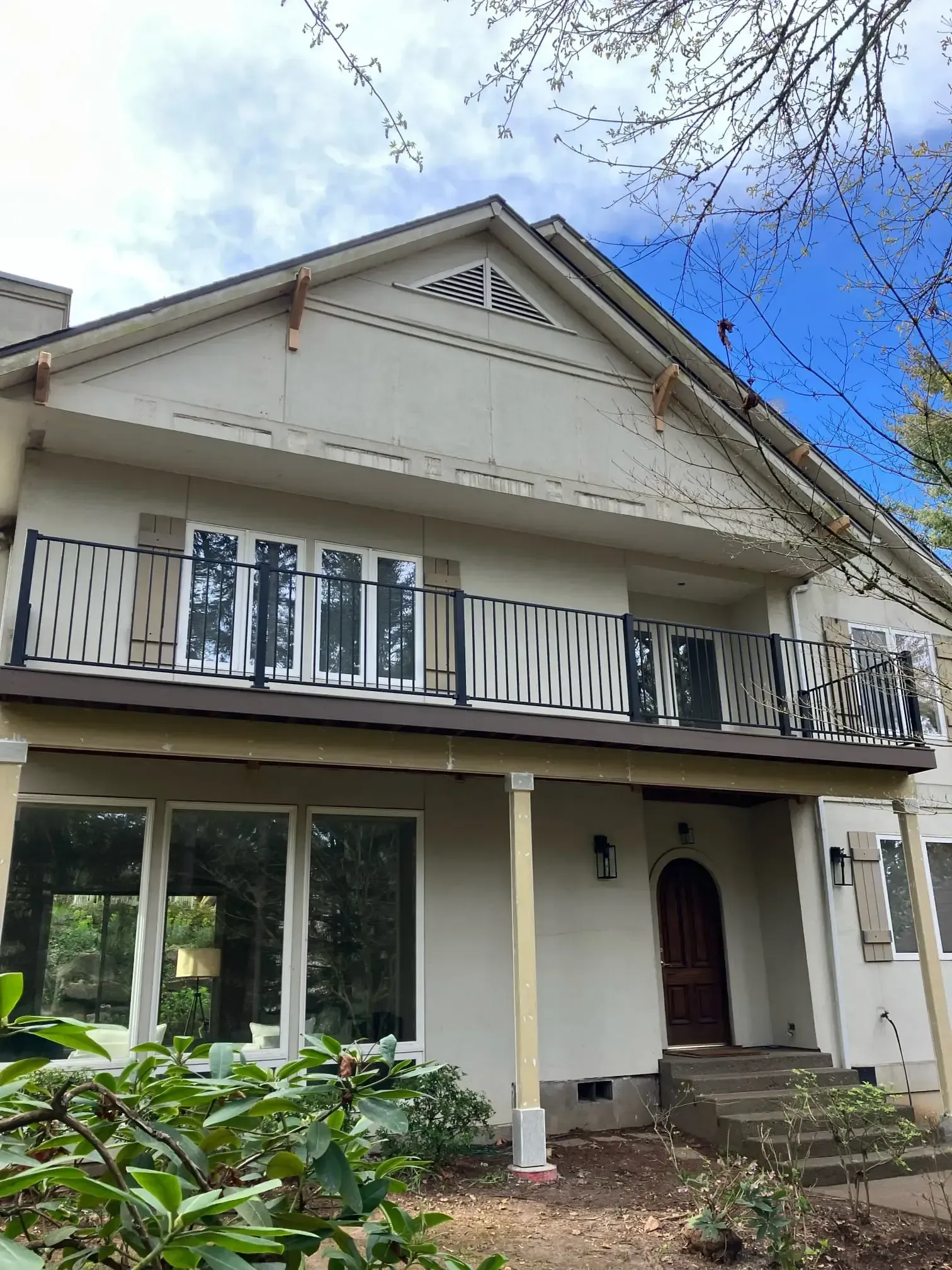 Second-story deck with white balusters on a stucco home.
