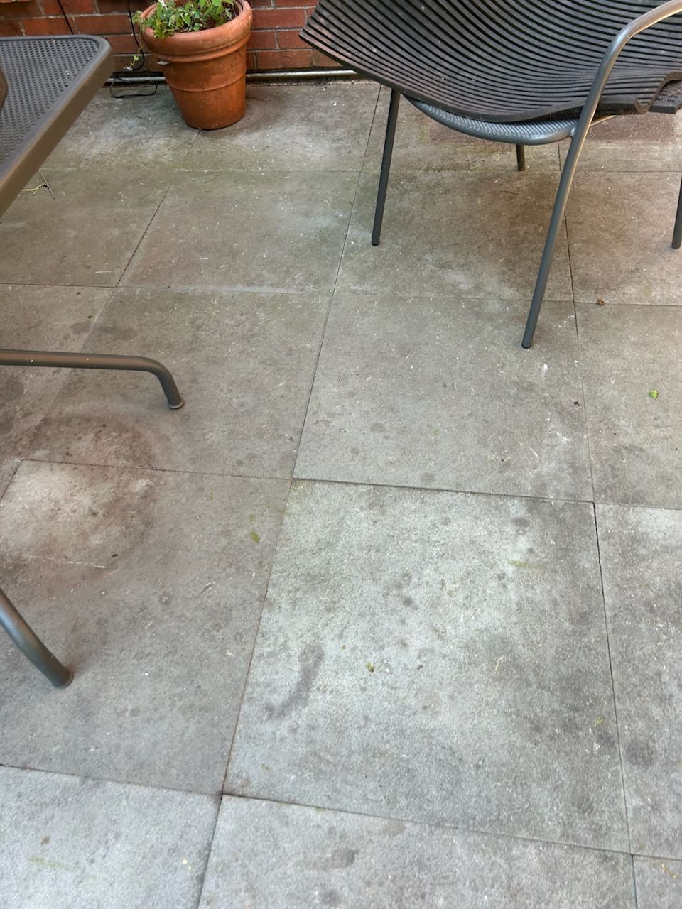 A patio with a table and chairs and a potted plant