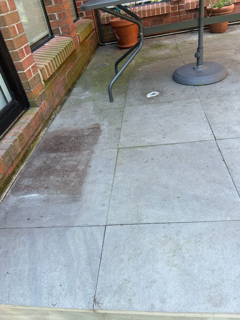 A patio with a table and potted plants on it