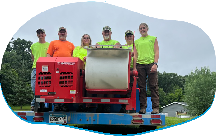 A group of men are posing for a picture in front of a house.