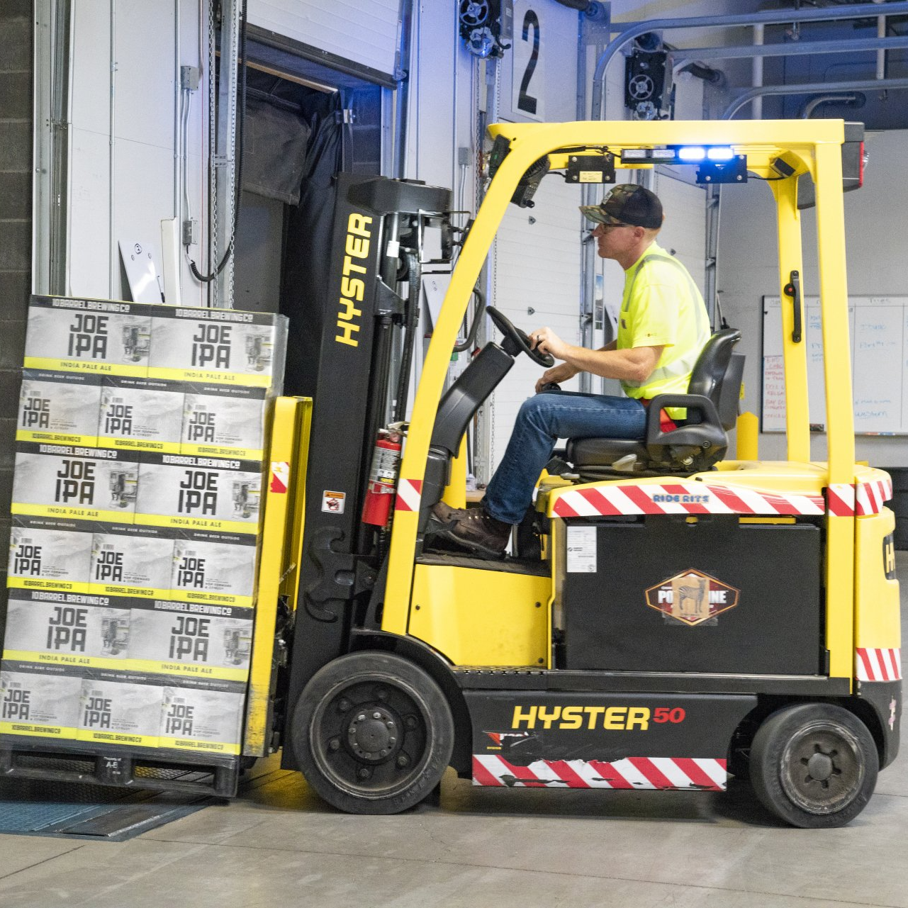 A forklift lifting a pallet of drinks