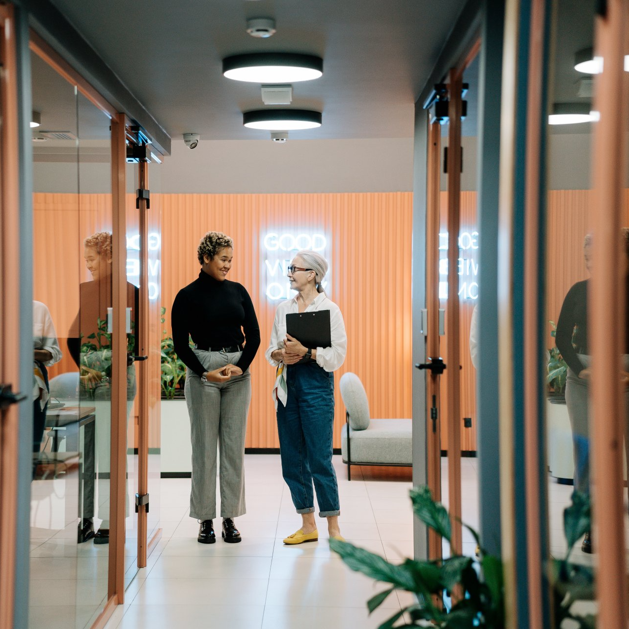 Two employees standing in a hallway talking