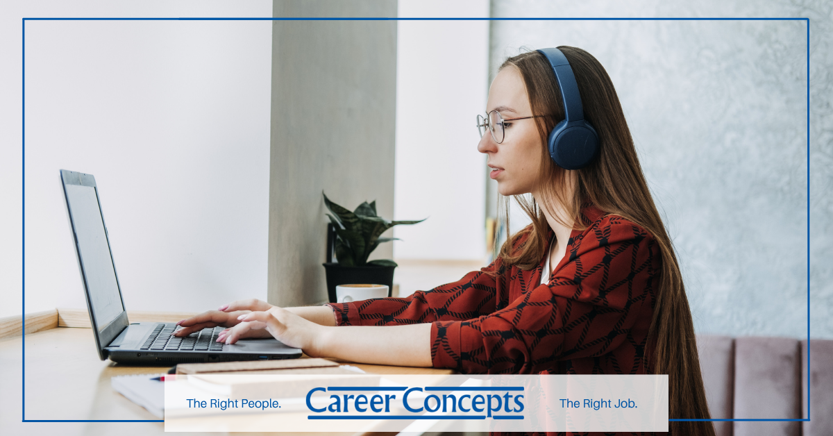 A woman wearing headphones at a laptop