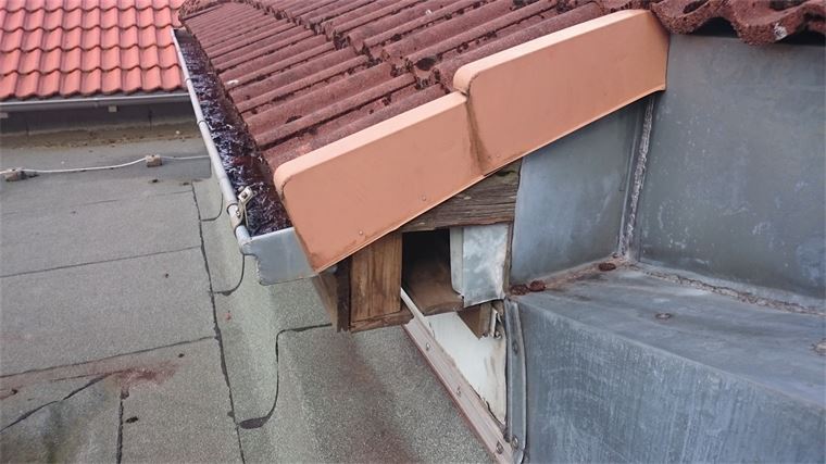 Ein Dach mit roten Ziegeln und einer Dachrinne darauf