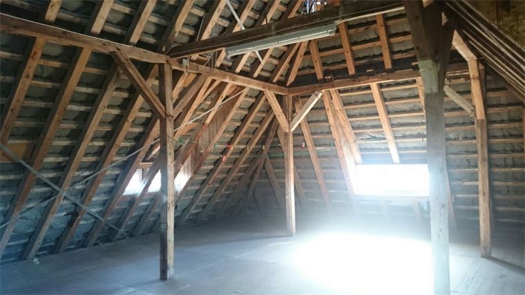 Auf dem Dachboden eines Gebäudes befindet sich ein Fenster.