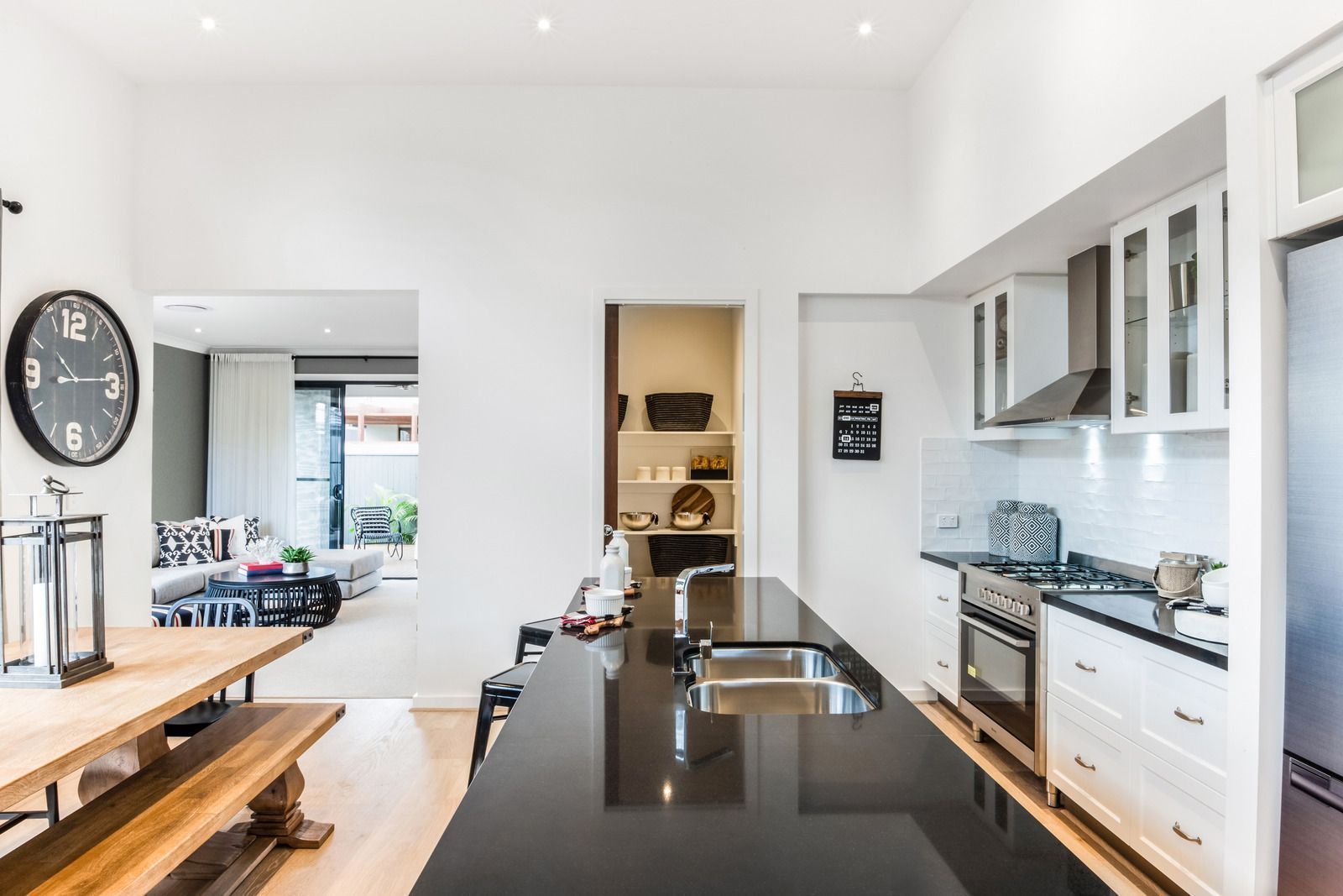 Modern kitchen with black island, white cabinets, and dining area visible.