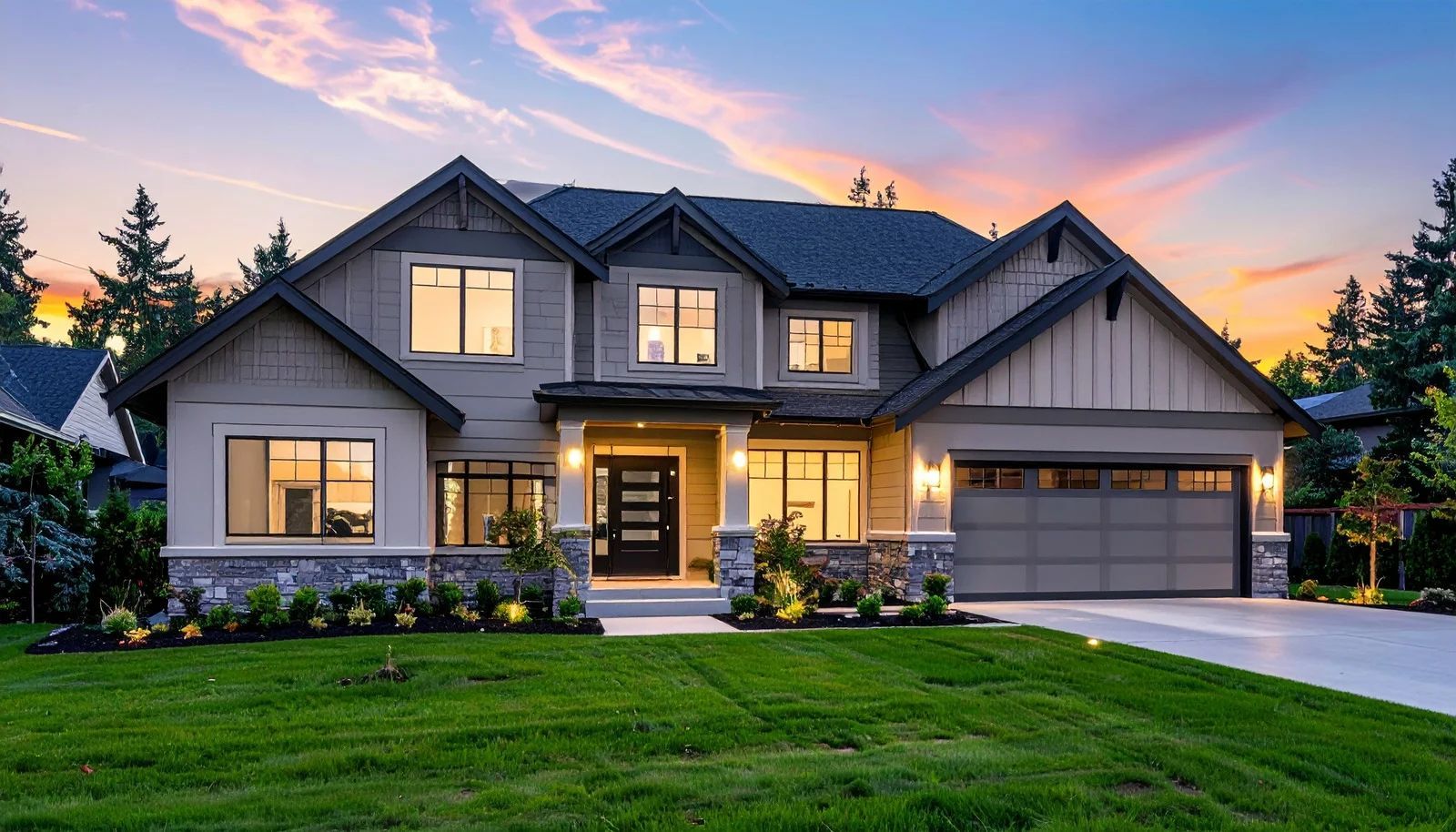 A large, modern two-story suburban house with a tan exterior, stone accents, and a garage at sunset.