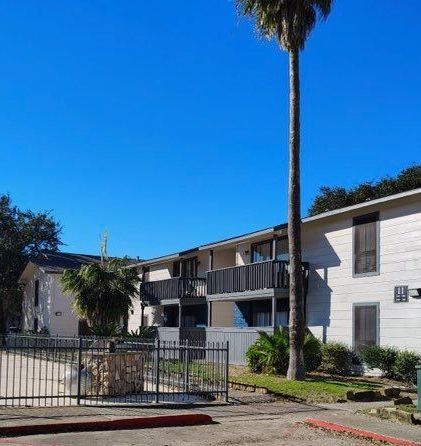 a house with a balcony and flowers in front of it
