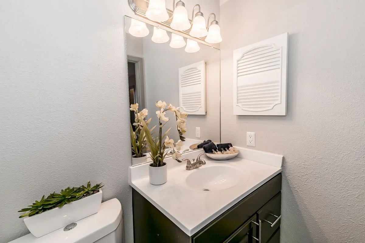 a bathroom with a sink a toilet and a mirror