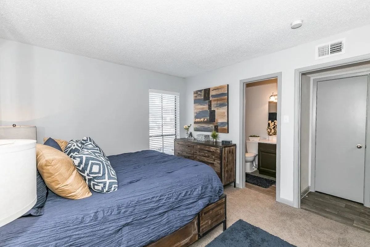 a bedroom with a blue bed and a dresser