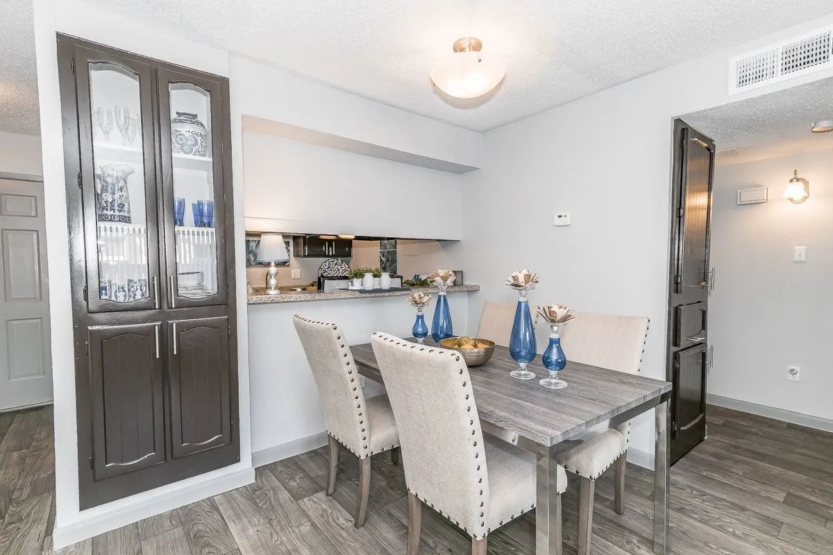 a dining room with a table and chairs and a glass cabinet