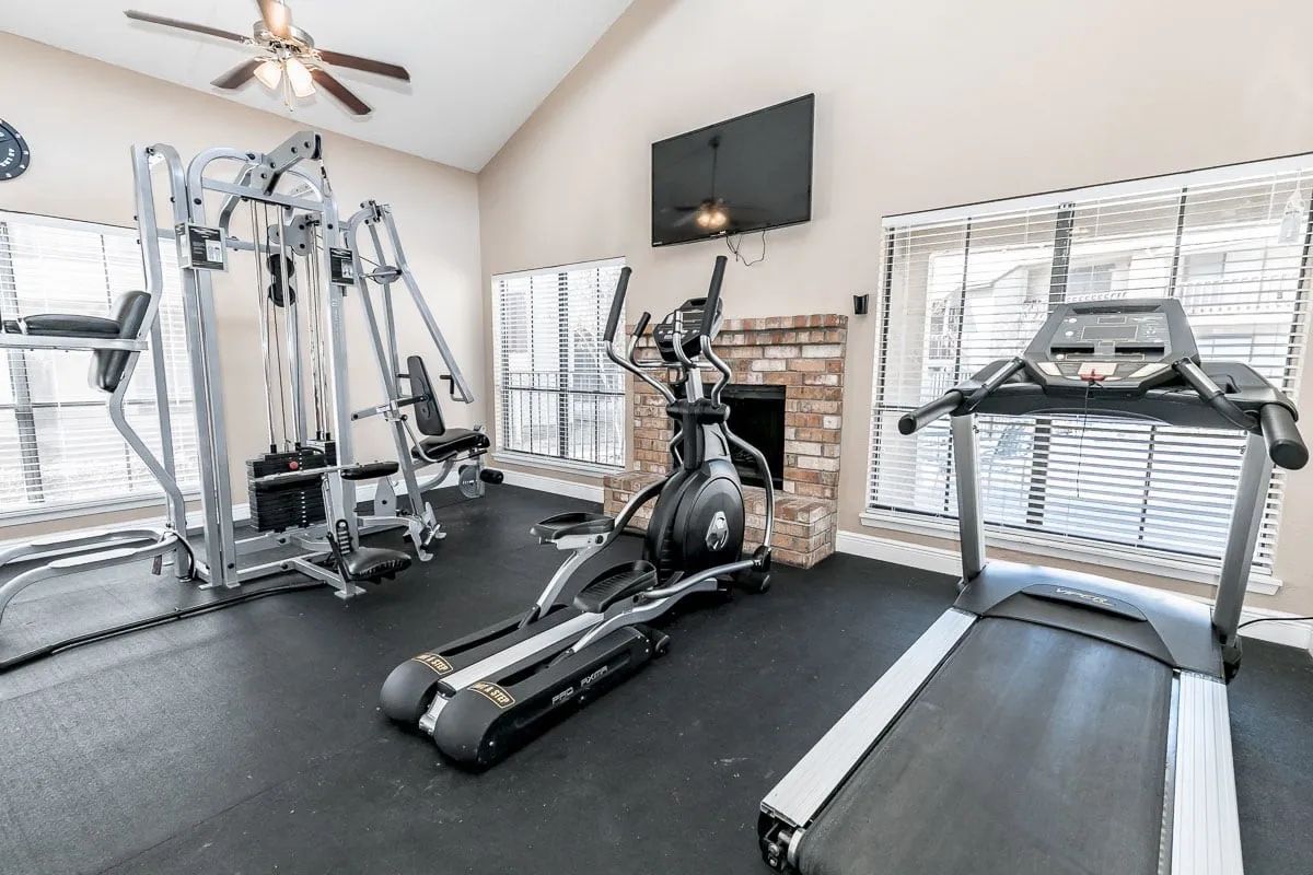 a gym with a treadmill and an elliptical