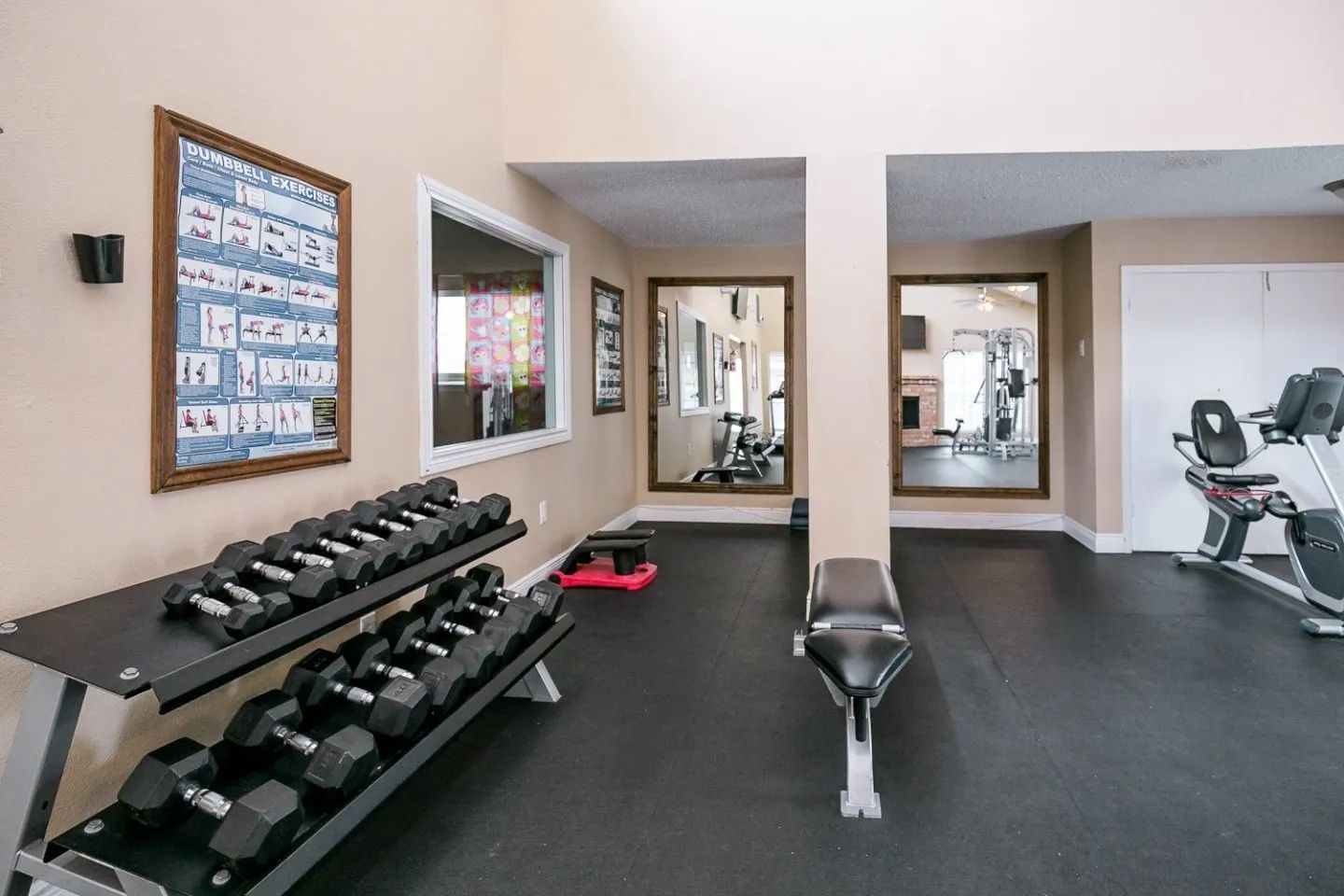 a gym with a poster on the wall that says dumbbell exercises