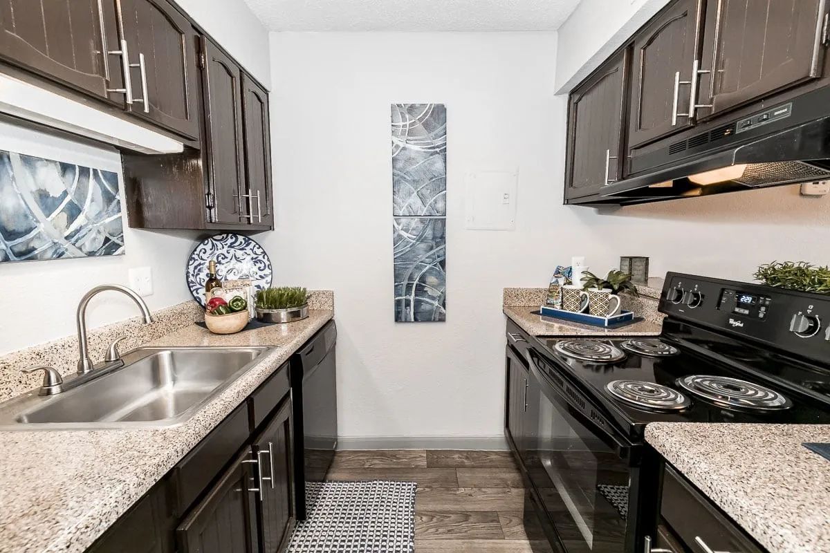 a kitchen with a stove top oven and a sink