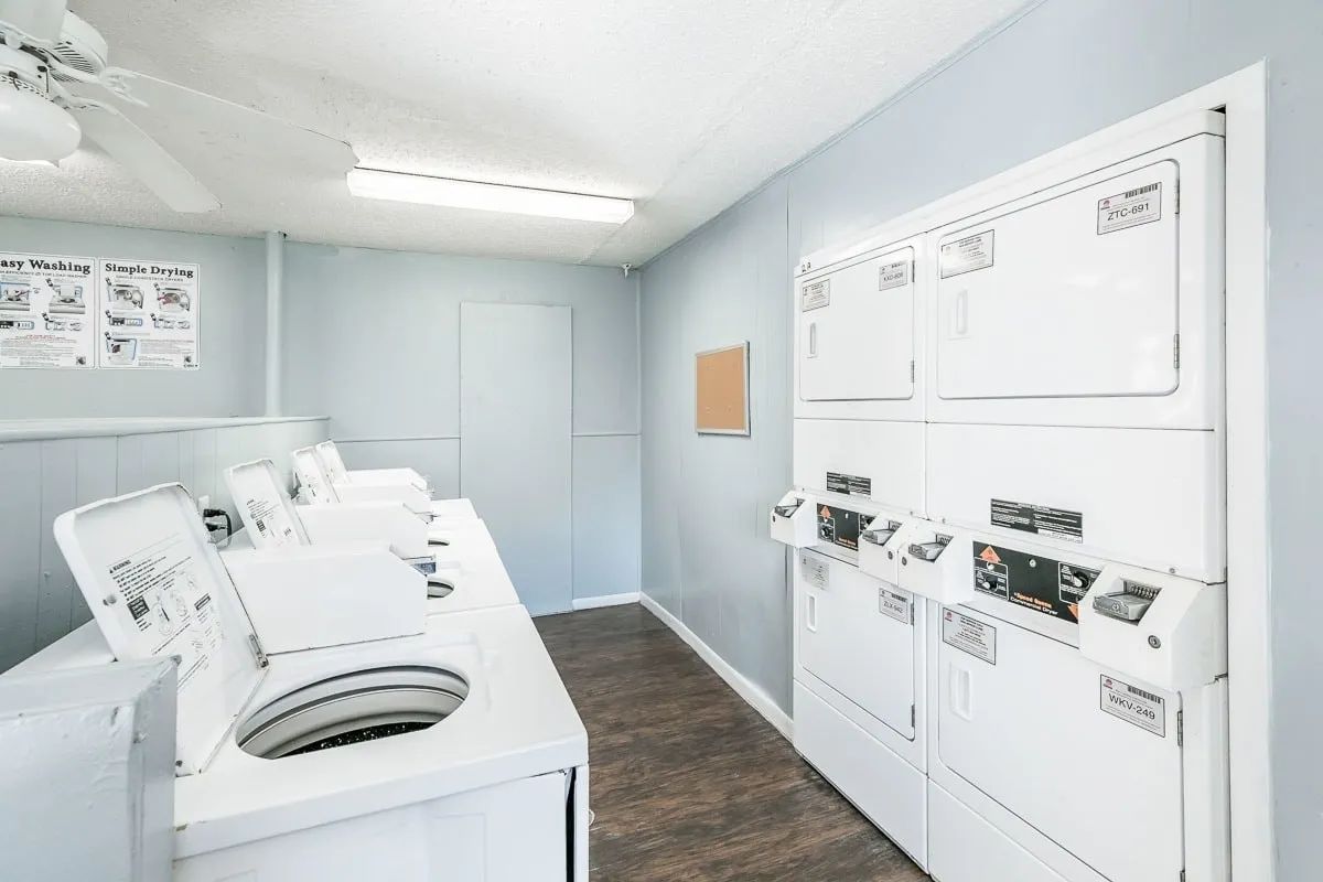 a row of washers and dryers in a laundromat