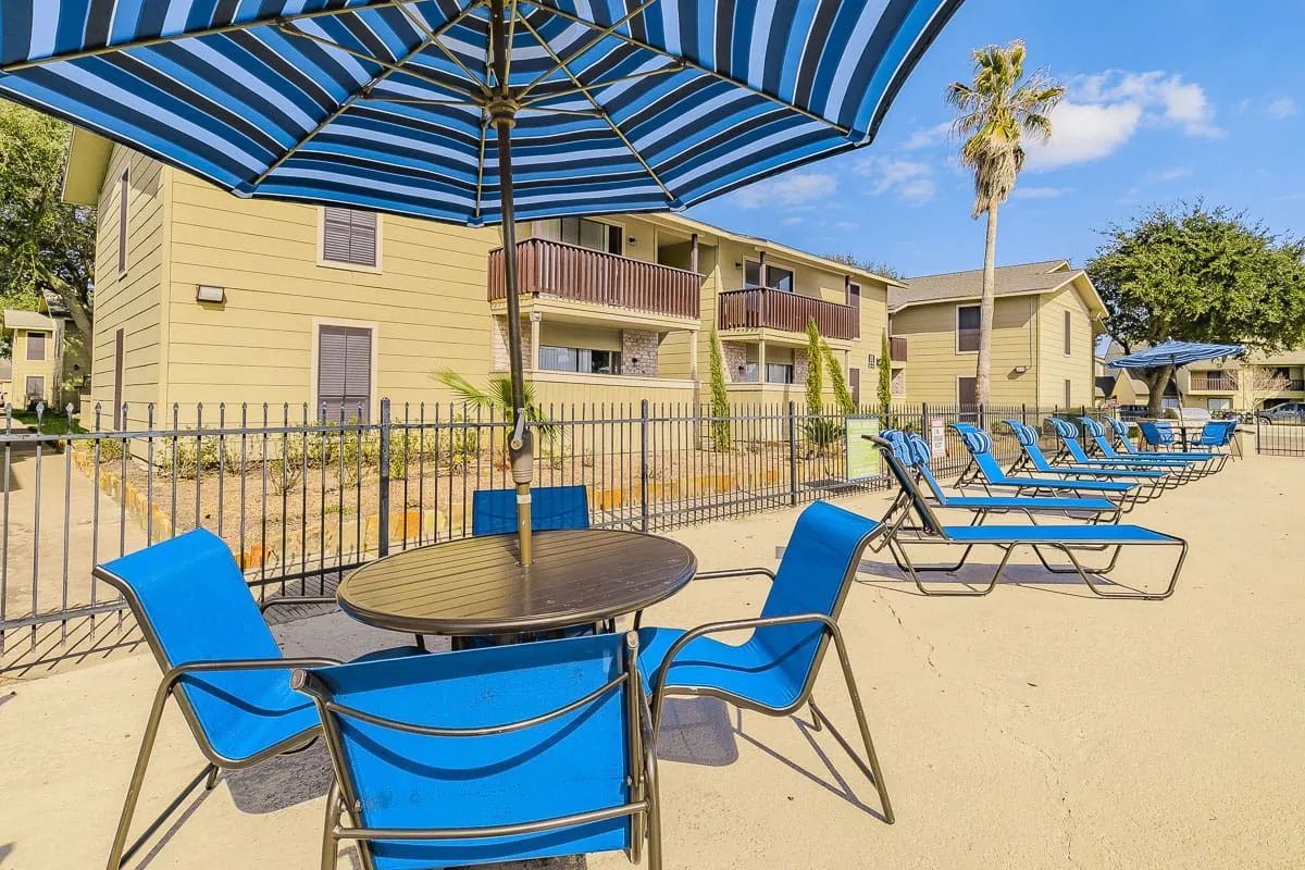 a table and chairs under an umbrella in front of a building