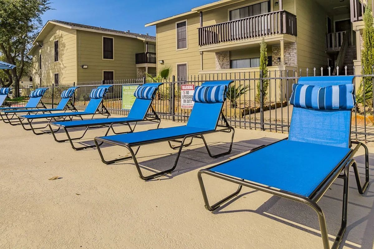 a row of blue lounge chairs in front of a building