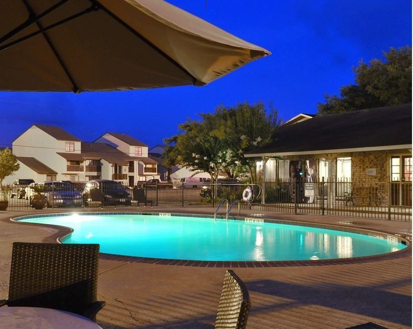 a large swimming pool is lit up at night