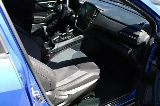 The interior of a blue car with the door open.