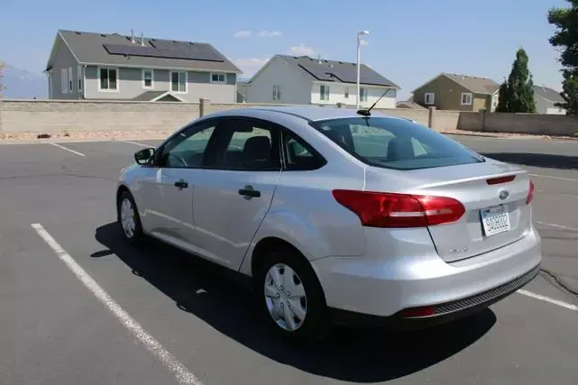 A silver ford focus is parked in a parking lot.