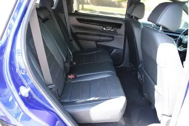 The back seat of a blue car with black seats