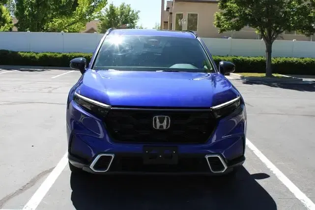 A blue honda cr v is parked in a parking lot.