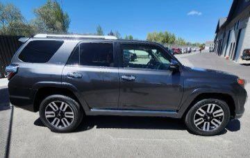 A toyota 4runner is parked in a parking lot in front of a building.