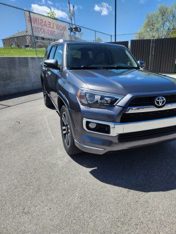 A toyota 4runner is parked in a parking lot next to a fence.