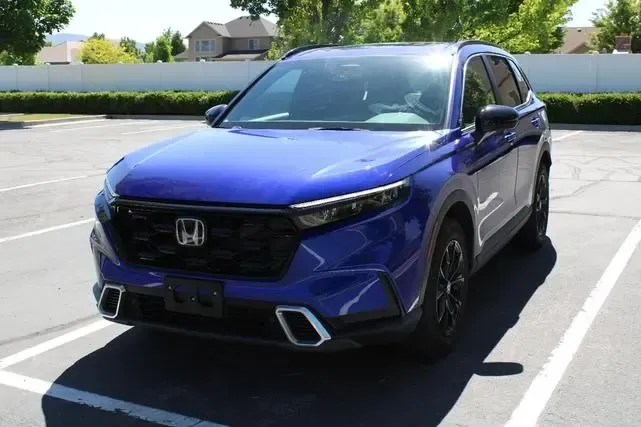 A blue honda is parked in a parking lot.