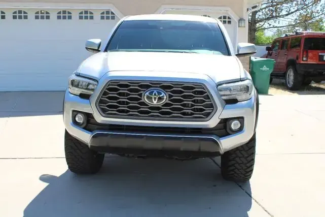 Silver Toyota Tacoma truck parked in front of a garage.