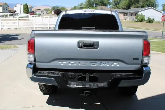 A silver tacoma truck is parked in a driveway