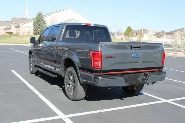 A black ford f150 truck is parked in a parking lot.