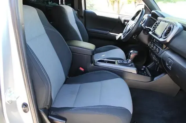 Interior view of a silver pickup truck, showing gray and black seats, center console, and dashboard.