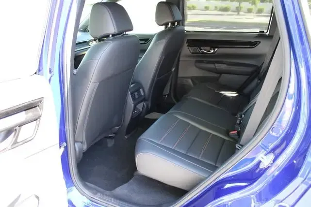 The back seat of a blue car with black seats.