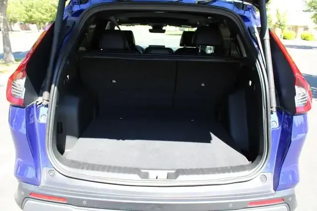 The trunk of a blue car is open and empty.