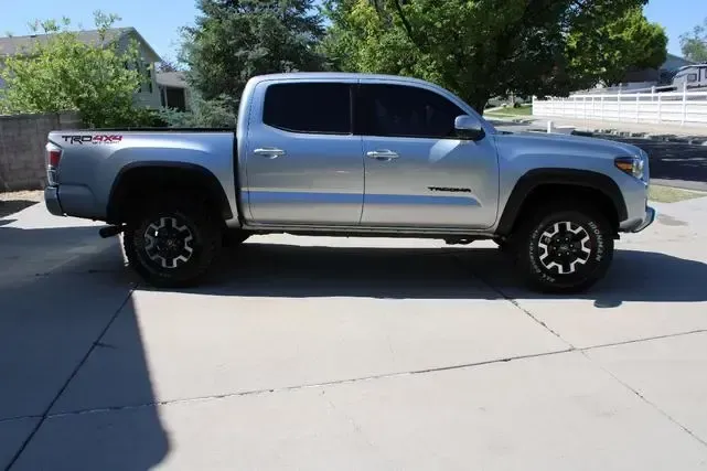 A silver truck is parked on the side of the road
