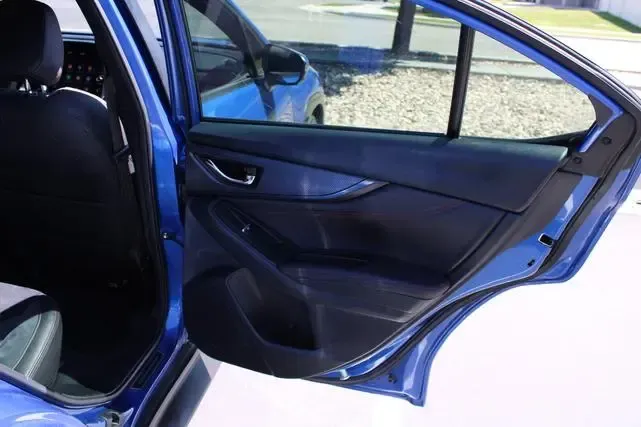 The back door of a blue car is open.