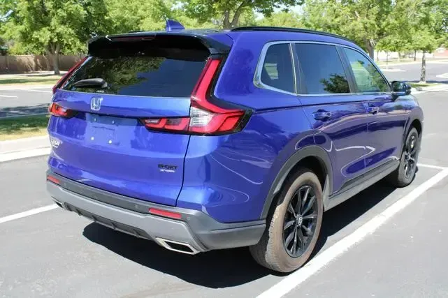 A blue honda pilot is parked in a parking lot.