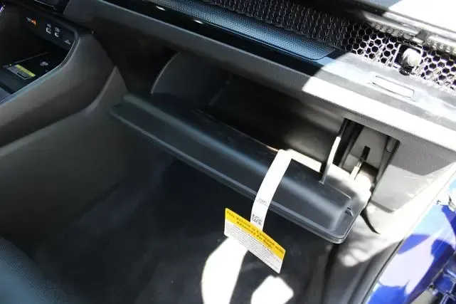 A person is holding a tag in the glove box of a car