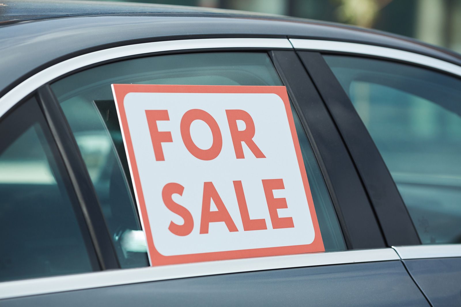 A car with a for sale sign in the window