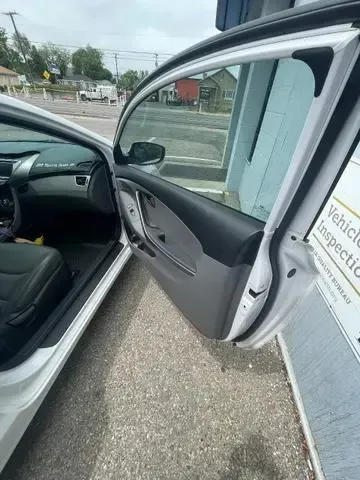 A white car with its doors open is parked on the side of the road.
