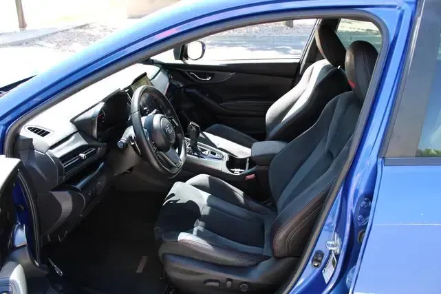 The interior of a blue car with the door open.