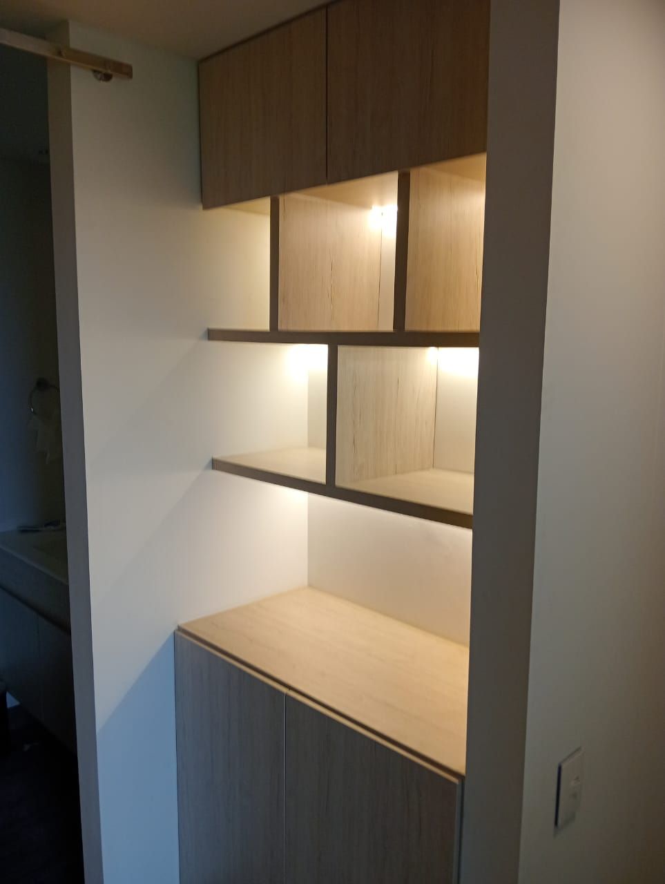 Un rincón de una habitación con estantes y armarios.