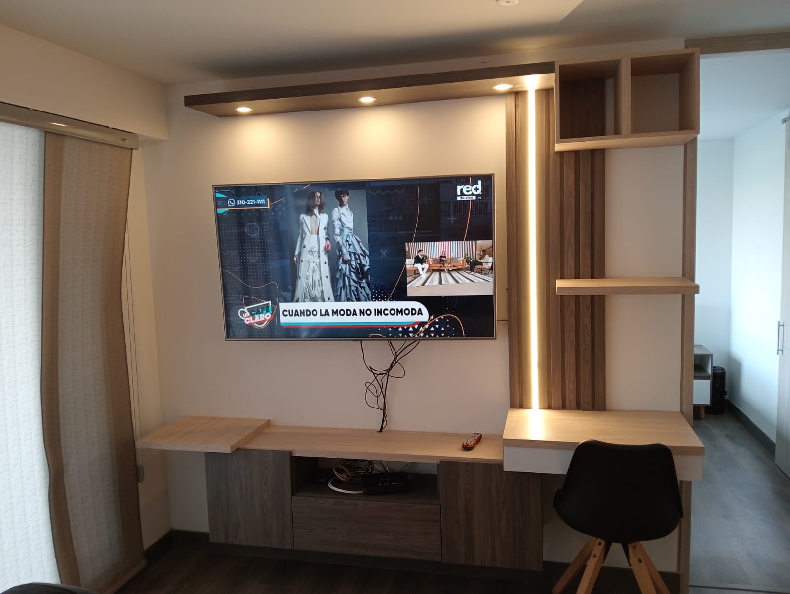 Un televisor de pantalla plana está colgado en una pared en una sala de estar.