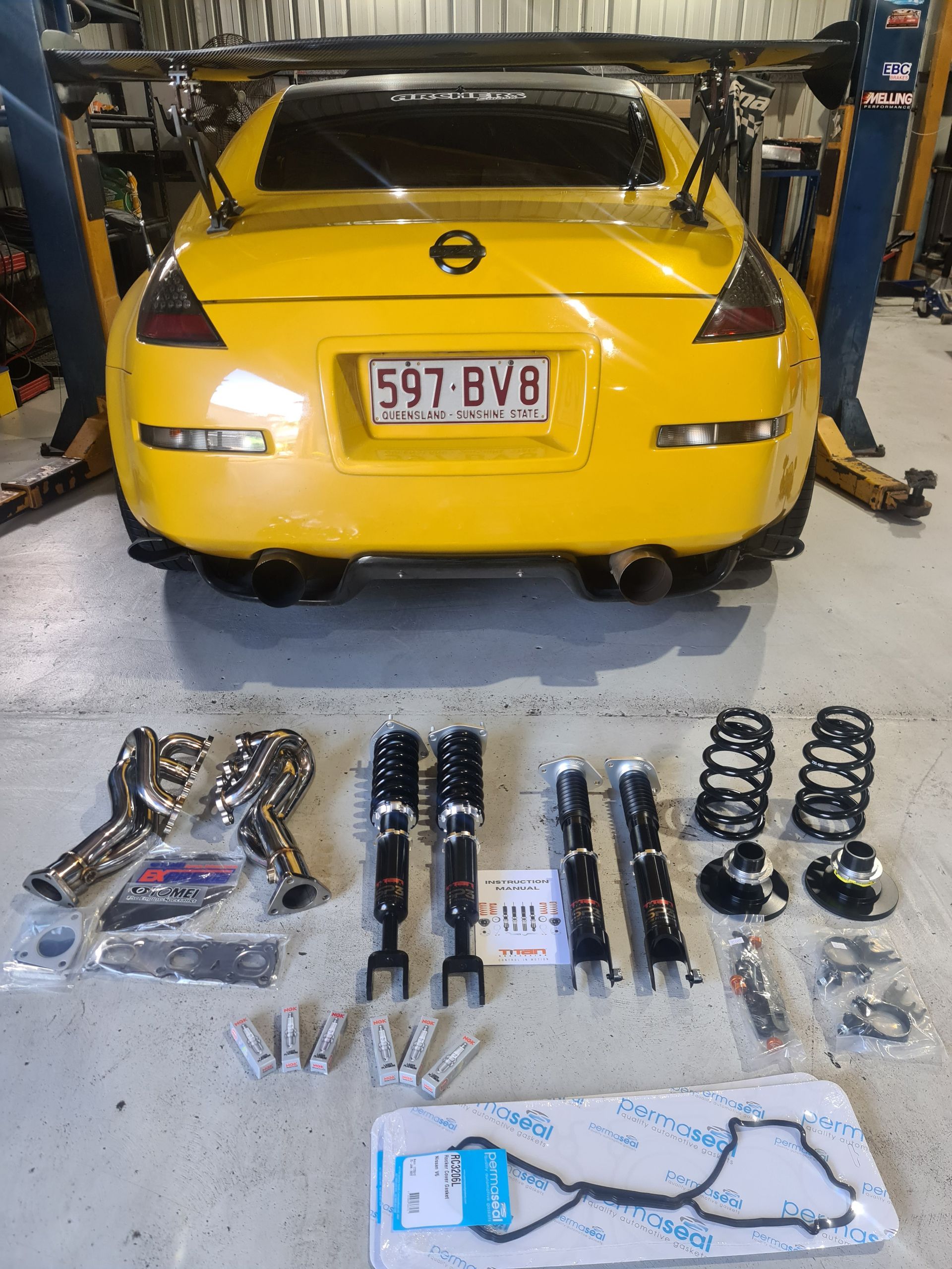 A Man is Working Underneath a Car in a Garage — Empire Automotive In Portsmith, QLD