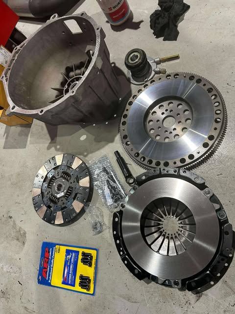 A Man is Fixing a Brake Disc on a Car in a Garage — Empire Automotive In Portsmith, QLD