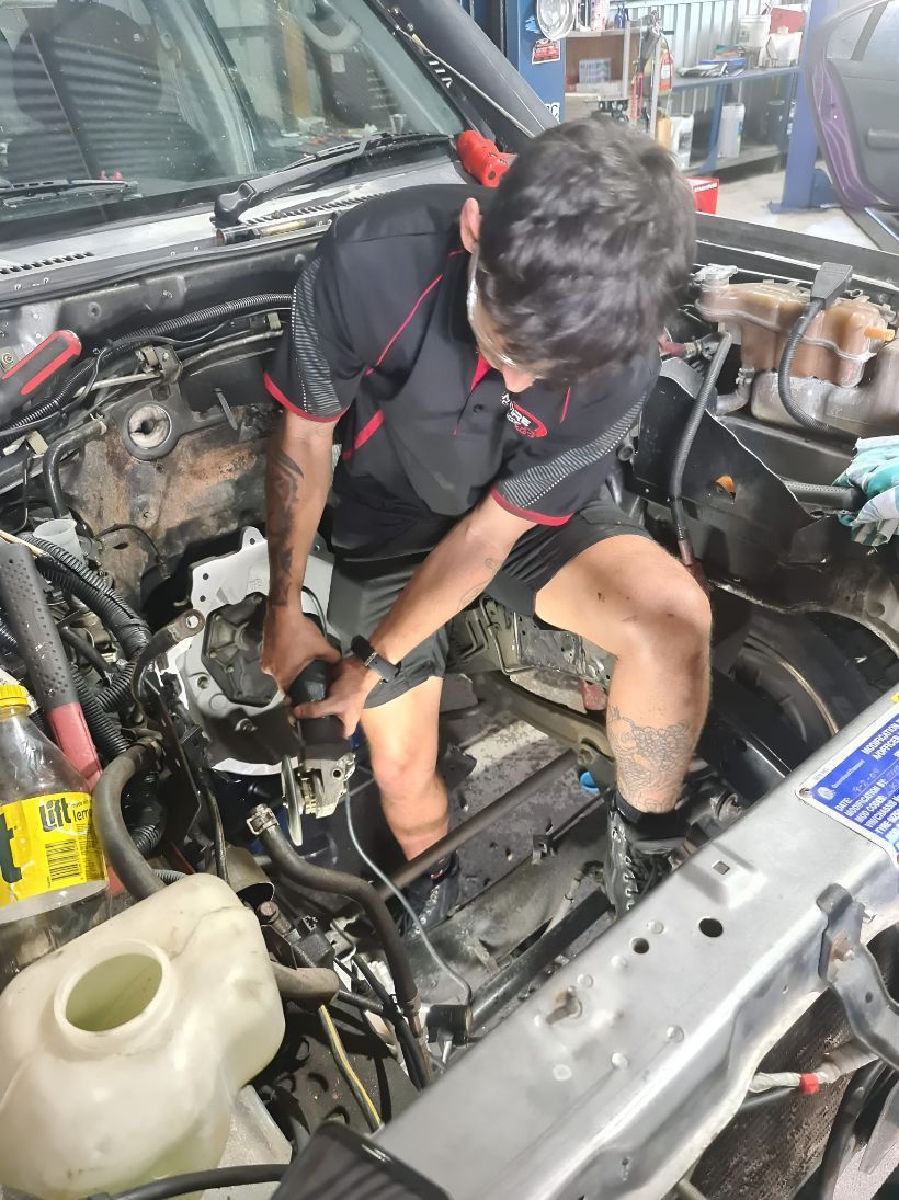 A Man is Working on the Engine of a Car — Empire Automotive In Portsmith, QLD