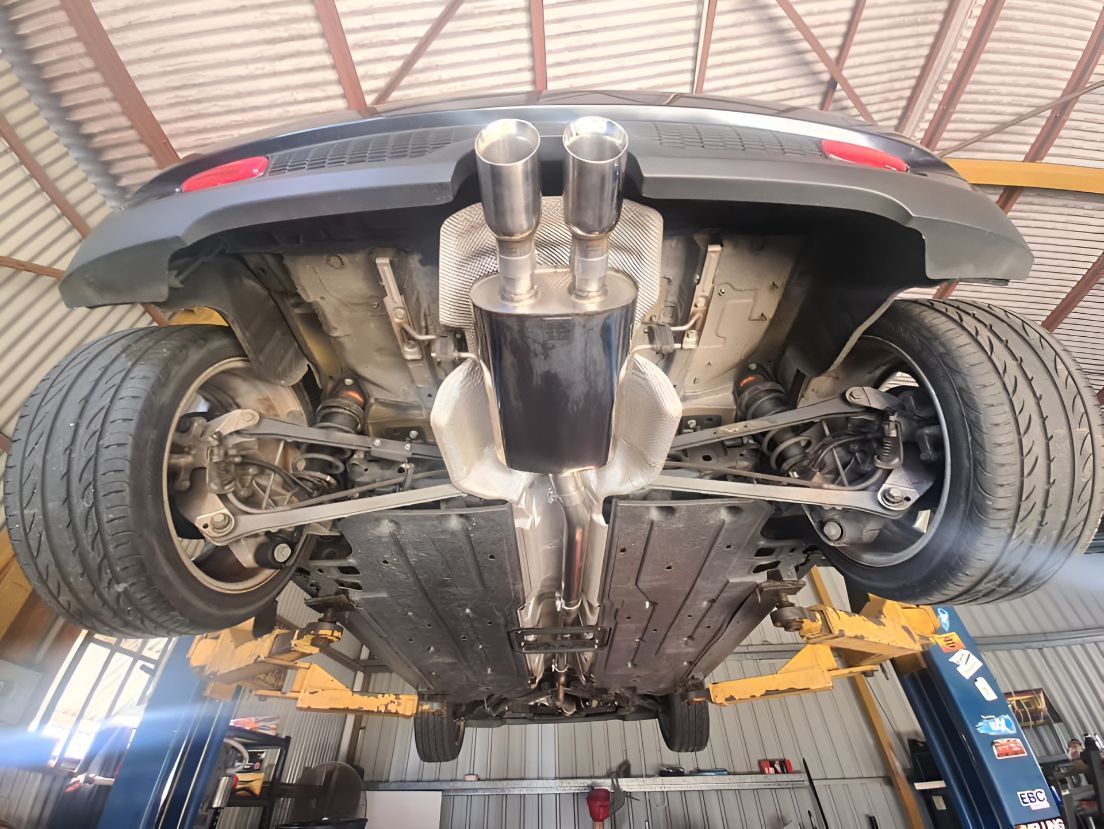 A Car is Sitting on a Lift in a Garage — Empire Automotive In Portsmith, QLD